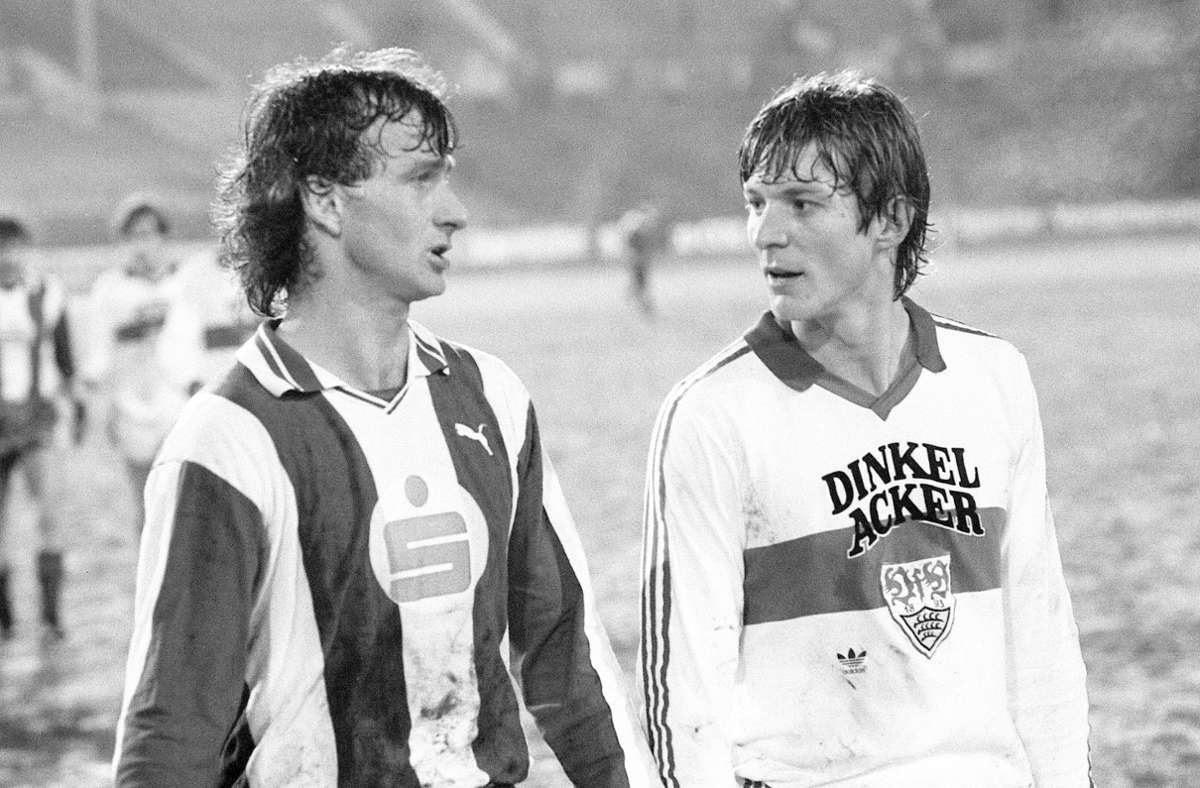 VfB Stuttgart: In den 80er Jahren prangte der Name der Stuttgarter Brauerei Dinkelacker auf der Brust der VfB-Akteure. Hier unterhalten sich Karl-Heinz Förster (rechts) und Rainer Bonhof (Hertha) bei einem Pokalspiel 19983 – sicher über das Feierabendbier.