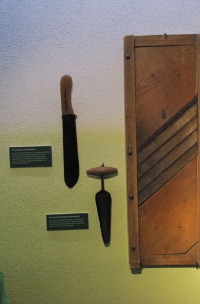 An der Wand hängen ein Krautmesser, ein Krautbohrer und ein Krauthobel.