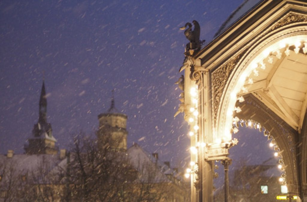 Sachte fallen Schneeflocken auf den mit Lichterketten geschmückten Pavillon am Stuttgarter Schlossplatz.