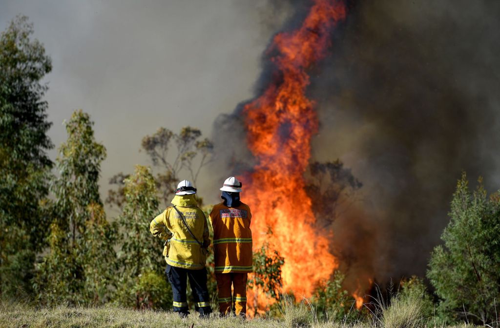 Einsatzkräfte der Feuerwehr beobachten ein Feuer in der Nähe eines Grundstücks am Wheelbarrow Ridge in Colo Heights, nordwestlich von Sydney.