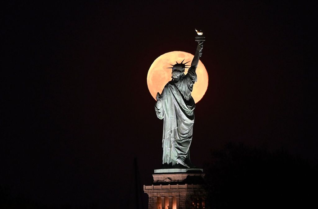 Die Freiheitsstatue in New York wurde vom Mond angestrahlt.