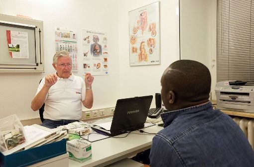 Ein Flüchtling aus Ghana im Gespräch mit einem Arzt. Foto: dpa