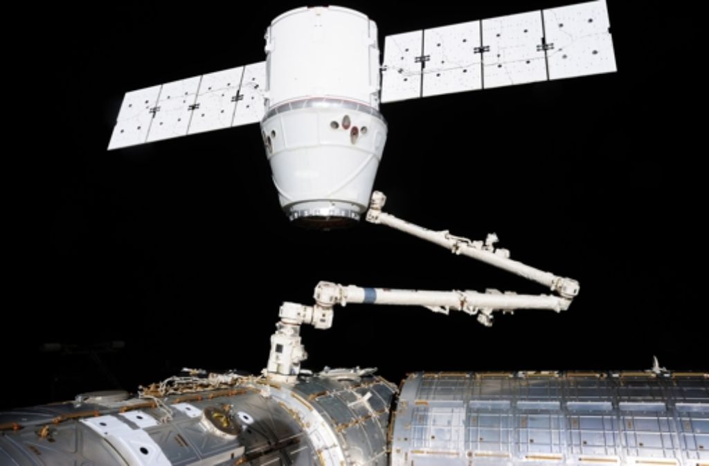 Das Raumschiff Dragon, hier ein Foto aus einem früheren Andockmanöver, hängt am Roboterarm der Raumstation ISS.