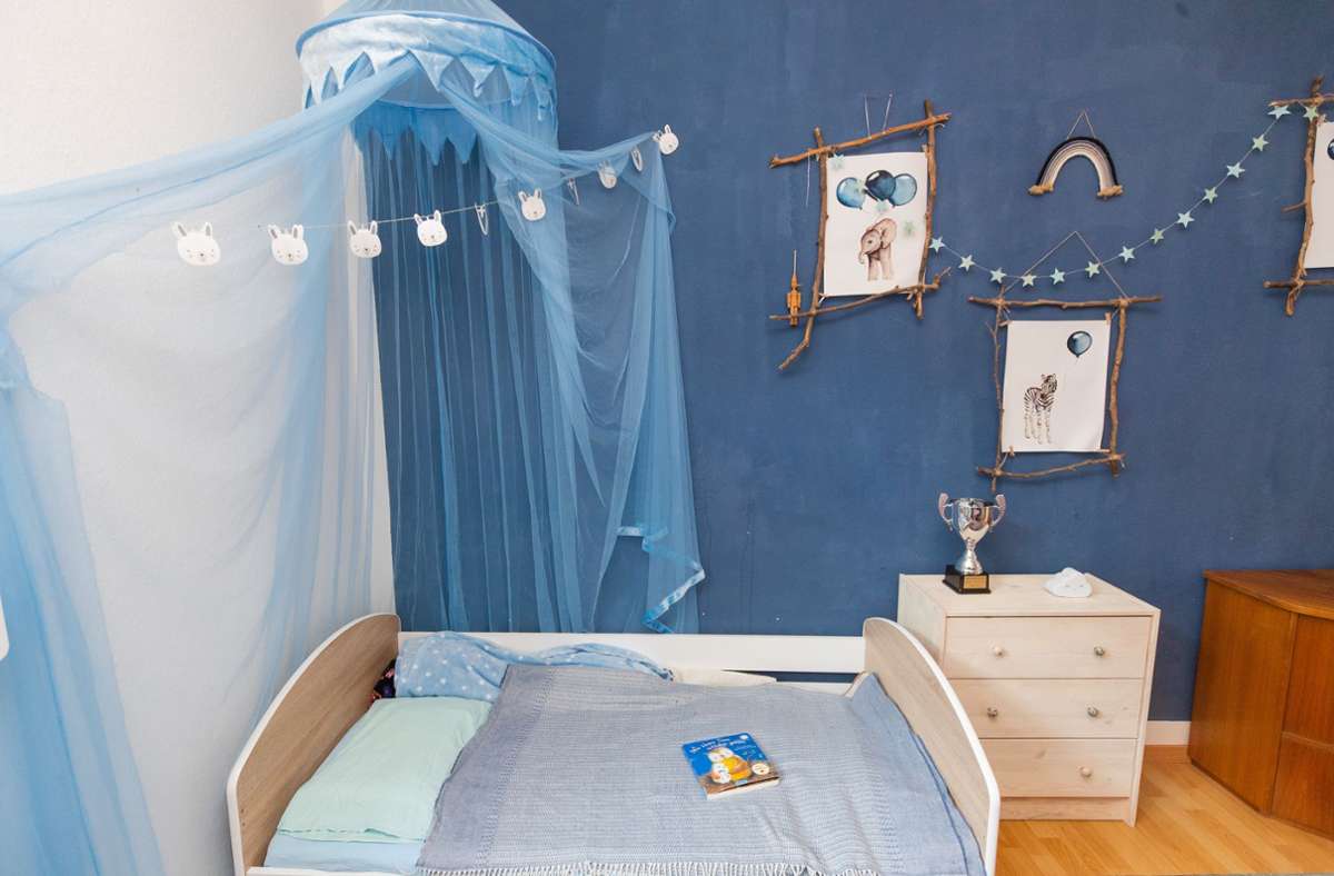 Blaue Wände und ein blauer Baldachin über dem Bett.