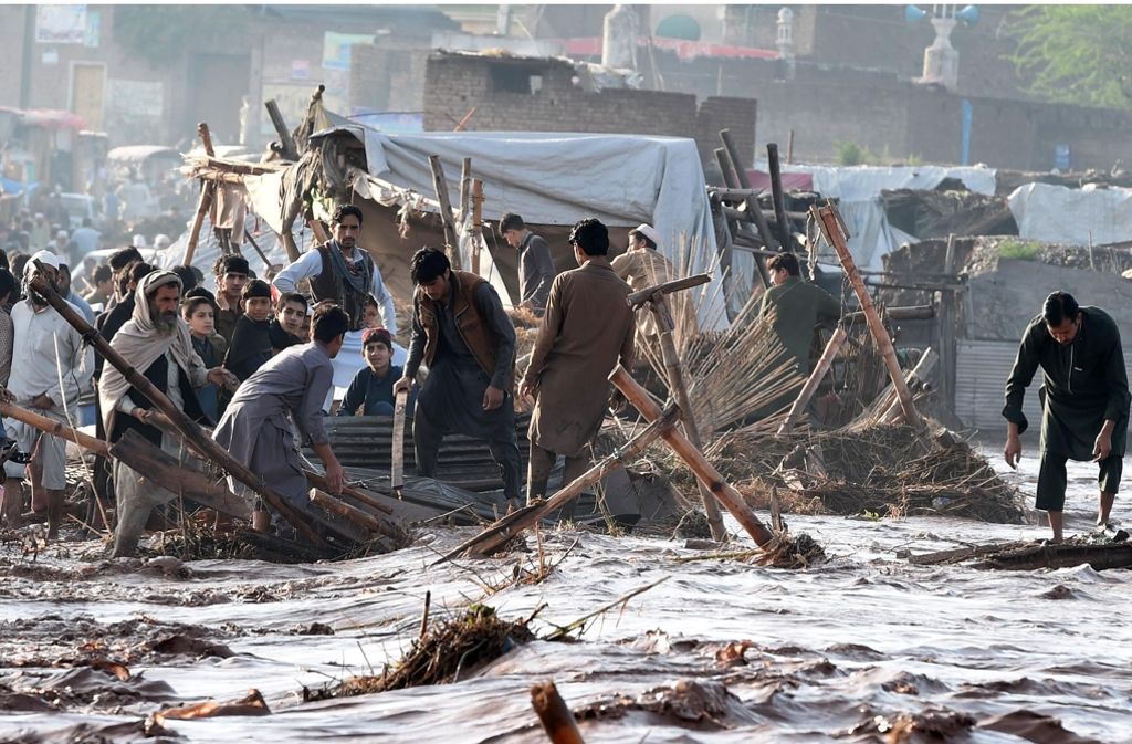 In der Stadt Peshawar versuchen Menschen notdürftig, Baumaterialien aus dem Schlamm zu fischen. Mindestens 53 Menschen wurden getötet, viele von ihnen wurden von einstürzenden Dächern erschlagen. Weitere 60 Menschen wurden verletzt.