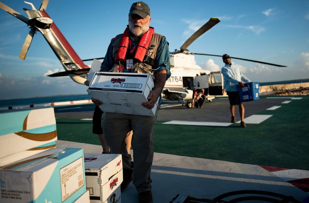 Ein Mann trägt Kisten einer Hilfsorganisation.