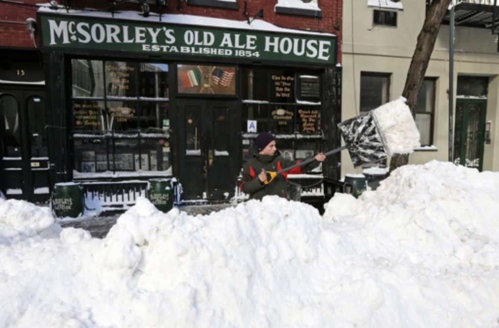 Ein Barbesitzer schaufelt seine Kneipe in New York frei.