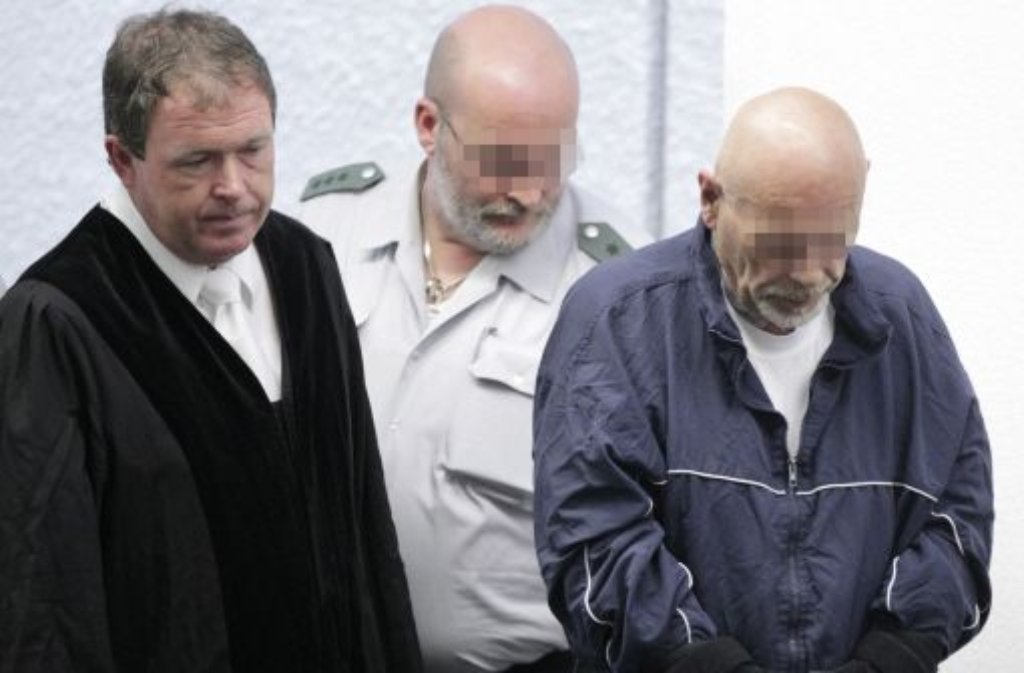 Der wegen Mordes angeklagte Detlef S. (re.) betritt im Landgericht in Stuttgart vor Beginn des Prozesses im Fall der sogenannten Parkplatzmorde neben seinem Anwalt Peter Mende (l.) und einem Justizbeamten den Gerichtssaal.