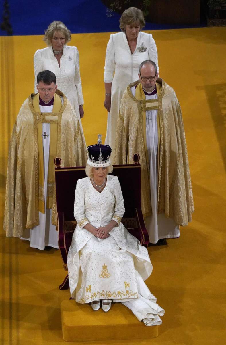 Königin Camilla trug ein silber- und goldbesticktes weißes Kleid von ihrem Lieblingsdesigner Bruce Oldfield.