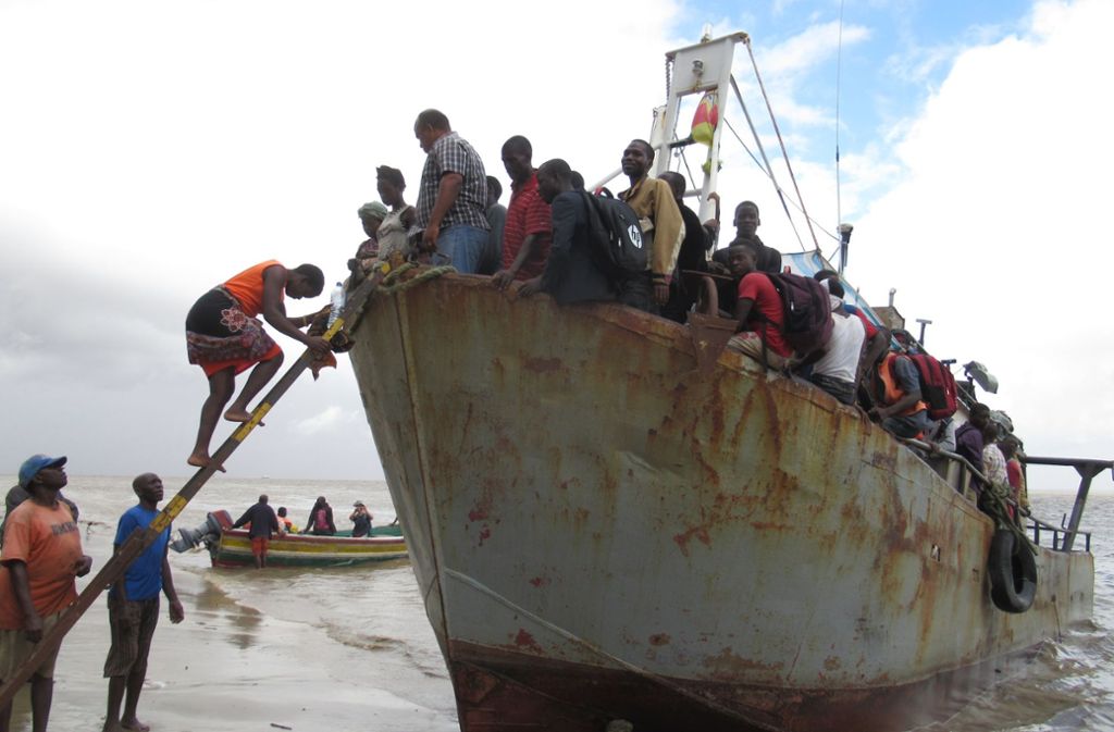 Ein Boot mit etwa 100 Menschen, die aus der überfluteten Region Búzi in Mosambik gerettet wurden, legt am Strand an. Das Schiff hatte zuvor den Hafen von Beira wegen der rauen See nicht erreichen können.