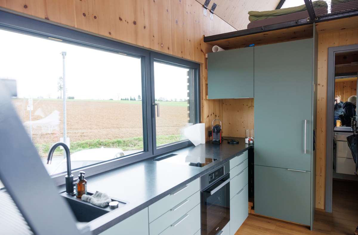 Auch eine komplette Küche ist dabei, ebenso ein Wohn- und Essbereich sowie ein Badezimmer.