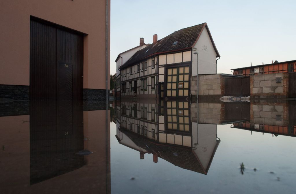 Häuser spiegeln sich in Harsleben (Sachsen-Anhalt) im Wasser der überfluteten Straßen.