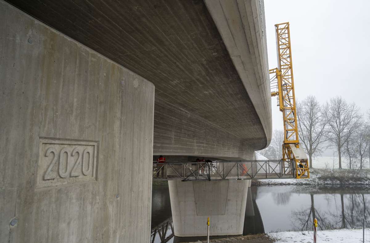 Mit Hilfe des Brückenuntersichtgeräts wird der Laufsteg unter das Bauwerk gehievt.