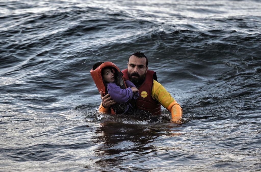 Ein spanischer Helfer rettet 2015 ein Kind, das auf einem sinkenden Schiff unterwegs war, aus dem Mittelmeer. Foto: AFP