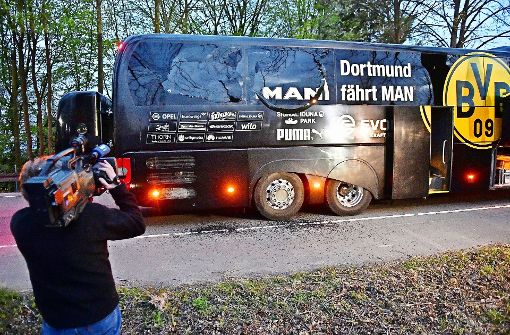 Das öffentliche Interesse ist groß: Ein Kameramann filmt den BVB-Bus kurz nach dem Bombenanschlag. Foto: AP