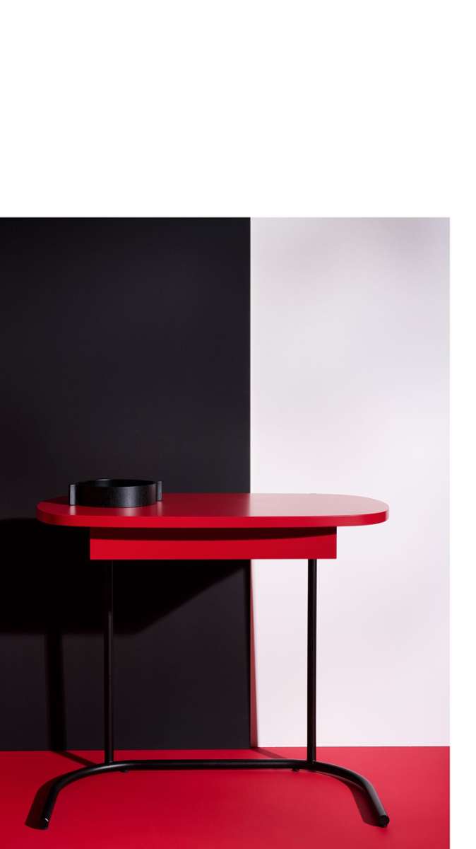 Steht gut da: Schreibtisch „TORI“ in Rot, entworfen von e-gg für Schönbuch mit ovaler Arbeitsplatte, dem filigranen Gestell und einer an die Tischplatte angepassten halbovalen Fußform.