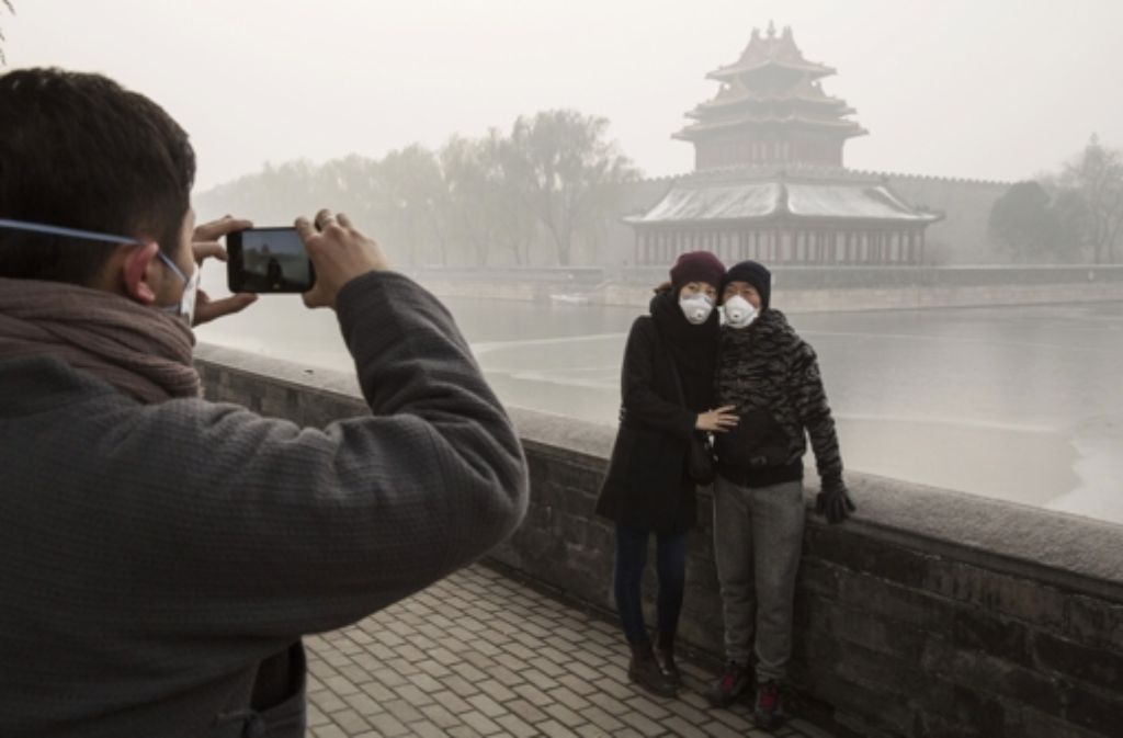 Bitte recht freundlich, auch wenn man von der Verbotenen Stadt im Hintergrund herzlich wenig erkennen kann. Die Luftverschmutzung in Peking hat unglaubliche Höchstwerte erreicht.