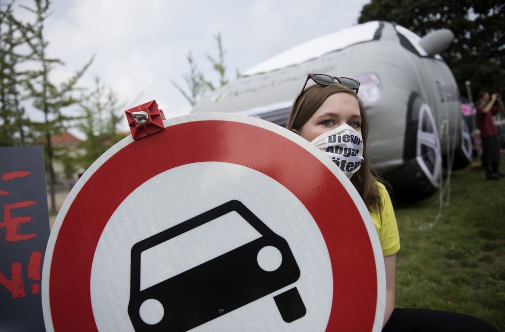 Eine Demonstrantin trägt in Berlin während einer Demonstration vor dem im Bundesverkehrsministerium stattfindenden «Diesel-Gipfel» einen Mundschutz mit der Aufschrift «Diesel-Abgase töten».