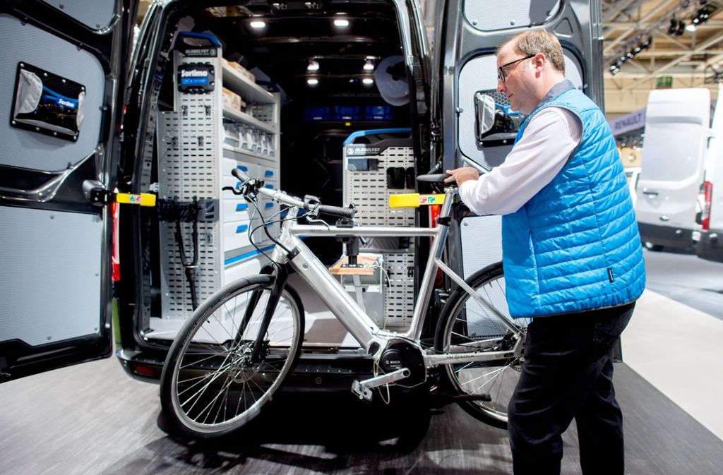 Ein Ford-Mitarbeiter zeigt die Funktionen einer mobilen Werkbank für Fahrradreparaturen, die im neuen Transit verbaut ist.