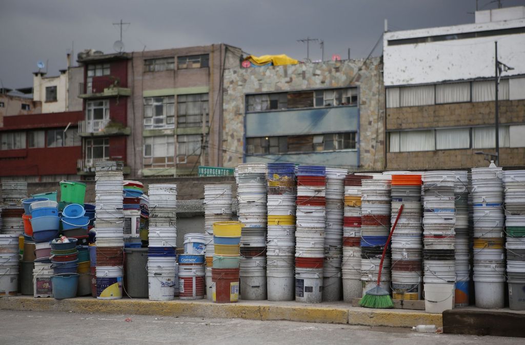 Plastik-Eimer, die zum Aufsammeln von Schutt benutzt wurden, stehen in Mexiko-Stadt aufeinander gestapelt an einer Straße.