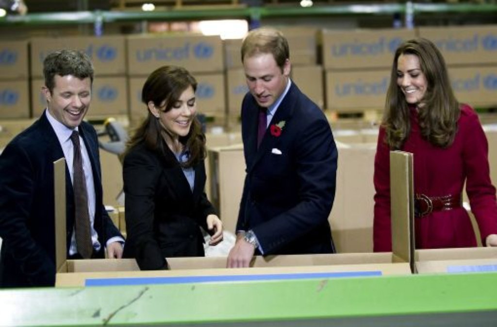 Zusammen mit dem dänischen Kronprinzen Frederik (links) und seiner Frau Mary bestücken der britische Prinz William und seine Frau Kate (rechts) Unesco-Hilfspakete.
