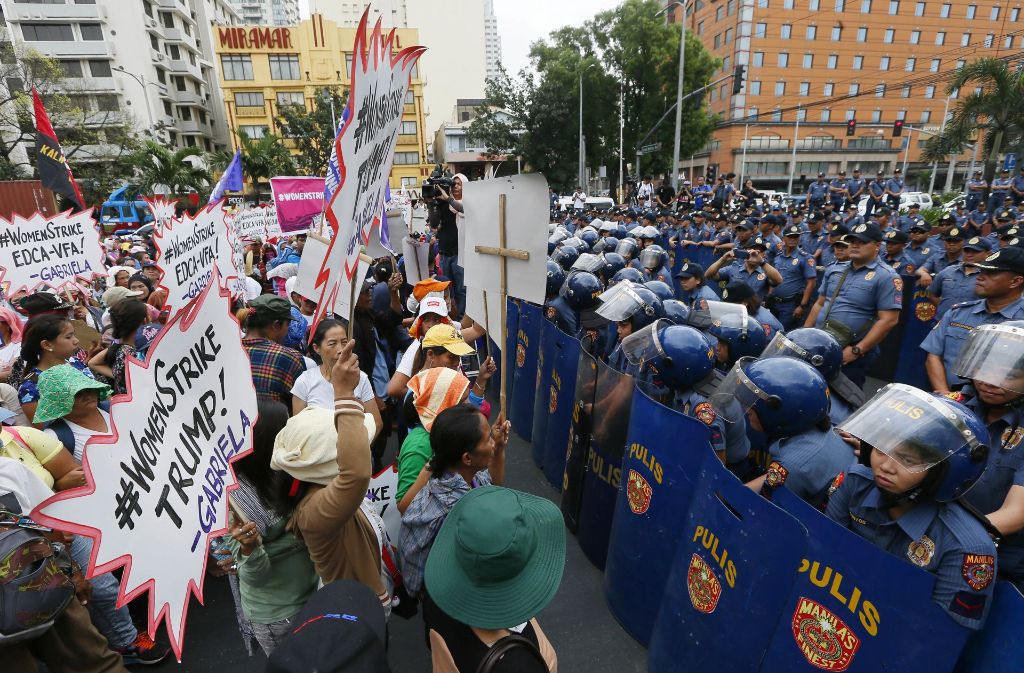 Demonstrantinnen und Polizistinnen stehen sich in der Nähe der US-amerikanischen Botschaft in Manila (Philippinen) auf einer Demonstration gegen die Politik des US-Präsidenten Trump gegenüber. Die Frauenrechts-Gruppe „Gabriela“ organisierte in Manila eine Demonstration anlässlich des Internationalen Frauentags.