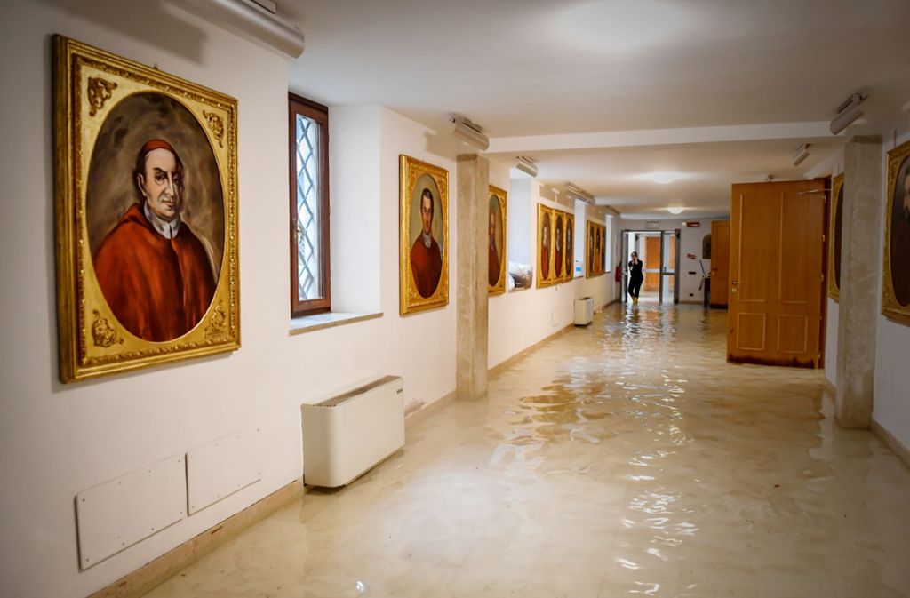 In einem Gang mit Gemälden an den Wänden hat sich durch das Hochwasser Wasser angesammelt.