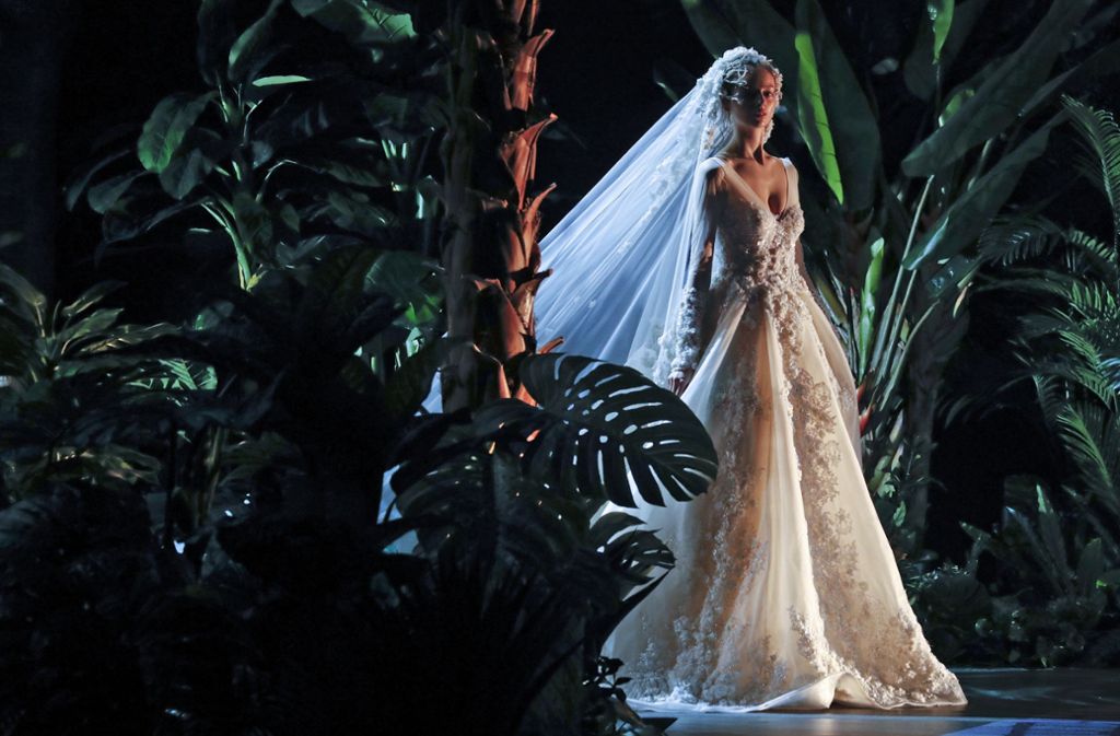 Traumhaft schöne Details machen dieses Brautkleid zu einer ganz besonderen Kreation. Der meterlange Schleier rundet das märchenhafte Hochzeitsoutfit ab.