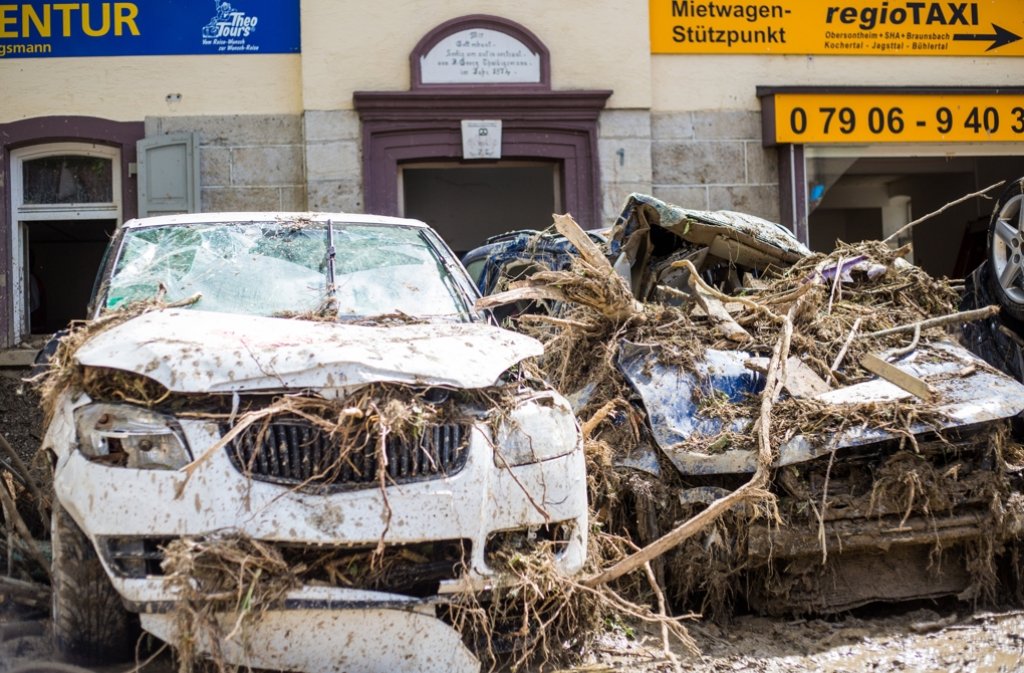 Zwei völlig zerstörte Autos stehen am 31. Mai 2016 bei Aufräumarbeiten an einer Straße im Ort.