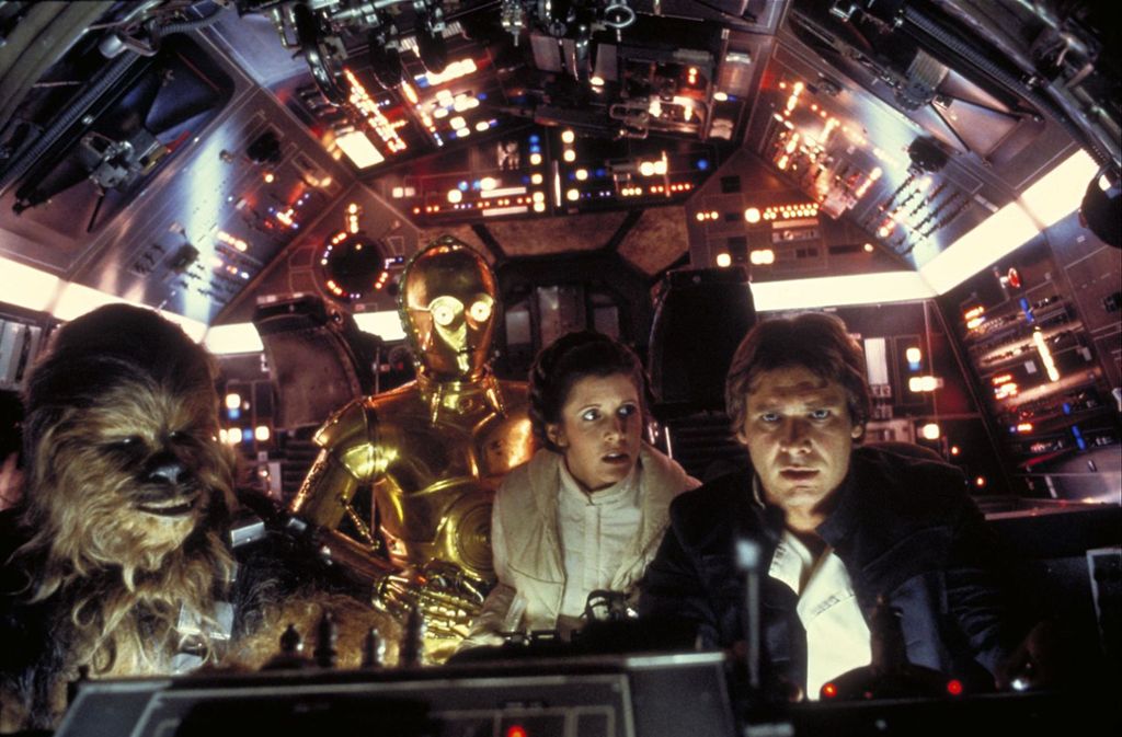 Chewbacca, der Roboter C-3PO, Prinzessin Leia Organa (Carrie Fisher) und Han Solo (Harrison Ford) in „Star Wars“ (1977).