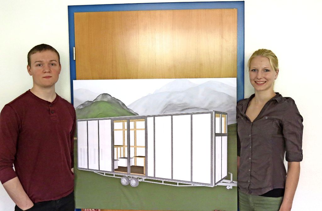Brendan Thome und Sina Martensen zeigen auf einem Plakat, wie die Tech Tiny Houses aussehen werden. Foto: Julia Bosch