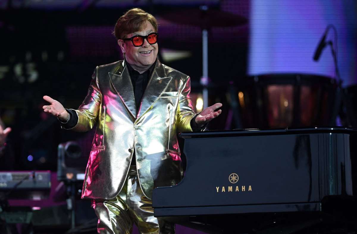 Die Welt ist rosarot: Elton John kombinierte zu seinem goldenen Anzug eine rot getönte Brille.
