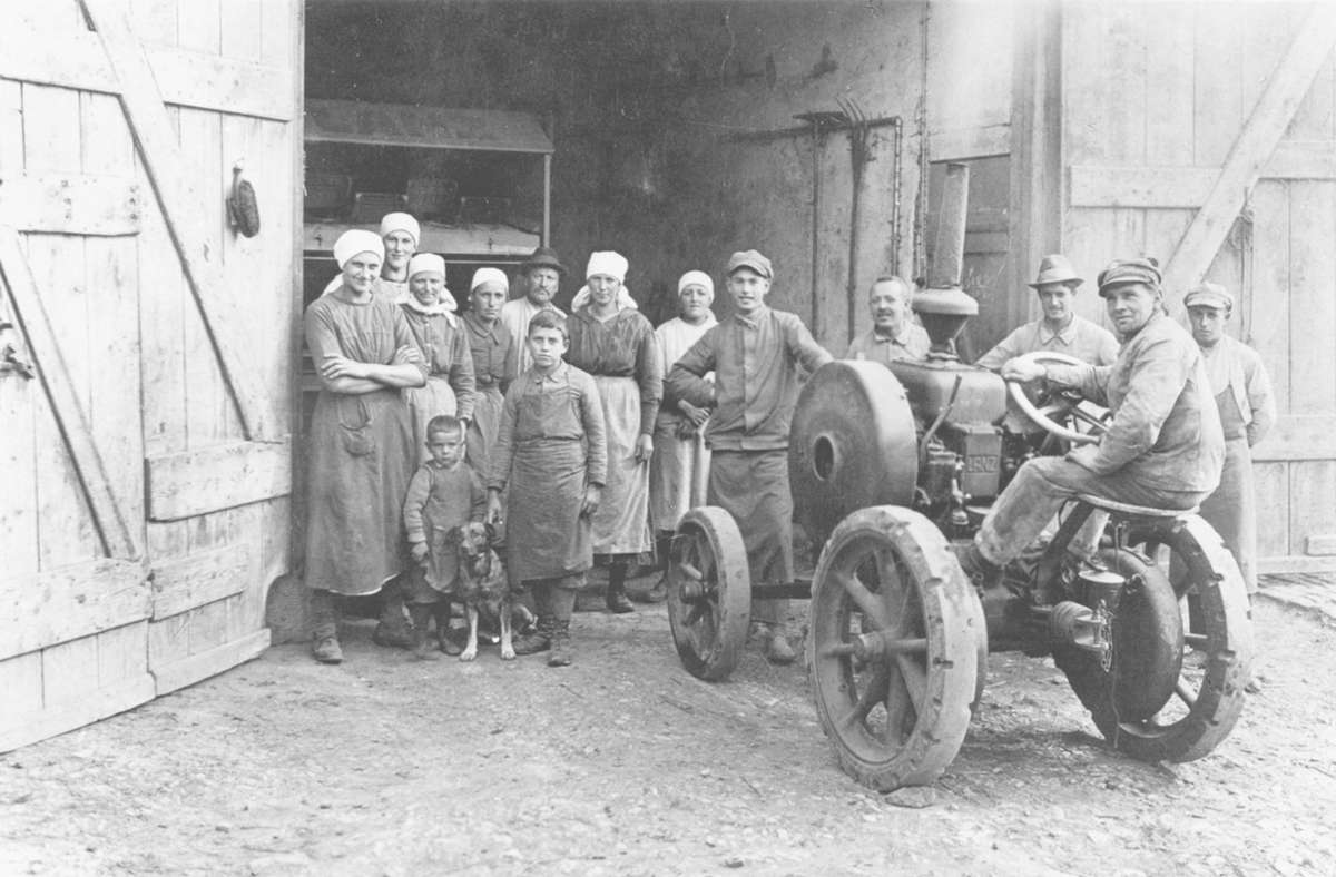 Stolz sitzt Nebenerwerbslandwirt August Harsch auf einem Lanz-Bulldog, der die Dreschmaschine in der Scheune antreiben konnte. Um 1922.