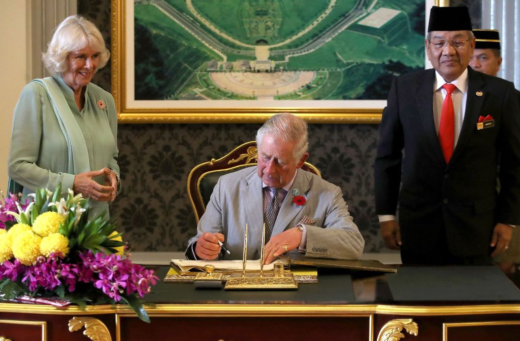 Der britische Prinz signiert in Kuala Lumpur vor einem Treffen mit dem malayischen König Sultan Muhammad V. das Gästebuch.