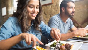 Eine Frau und ein Mann sitzen in einem Restaurant und essen.