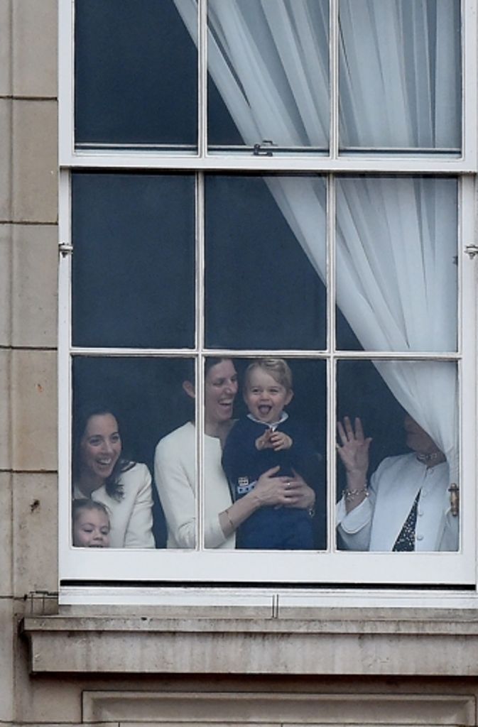 Kates und Williams Sohn, der kleine Prinz George, verfolgt die Parade vom Fenster des Buckingham Palasts aus.