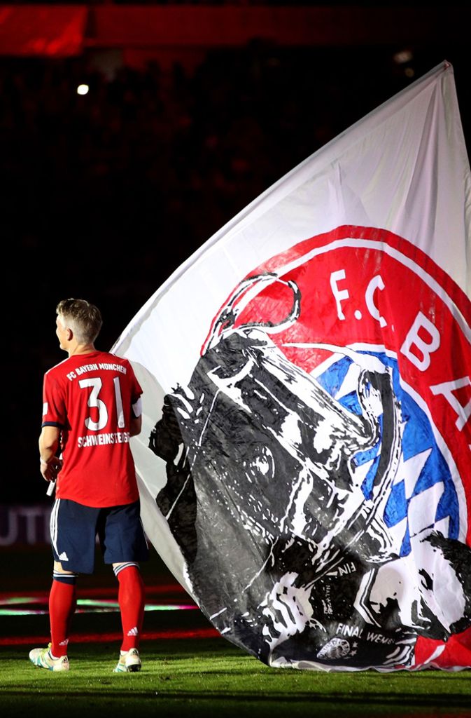 Bastian Schweinsteiger mit einer großen Fahne aus dem Bayern-Block.