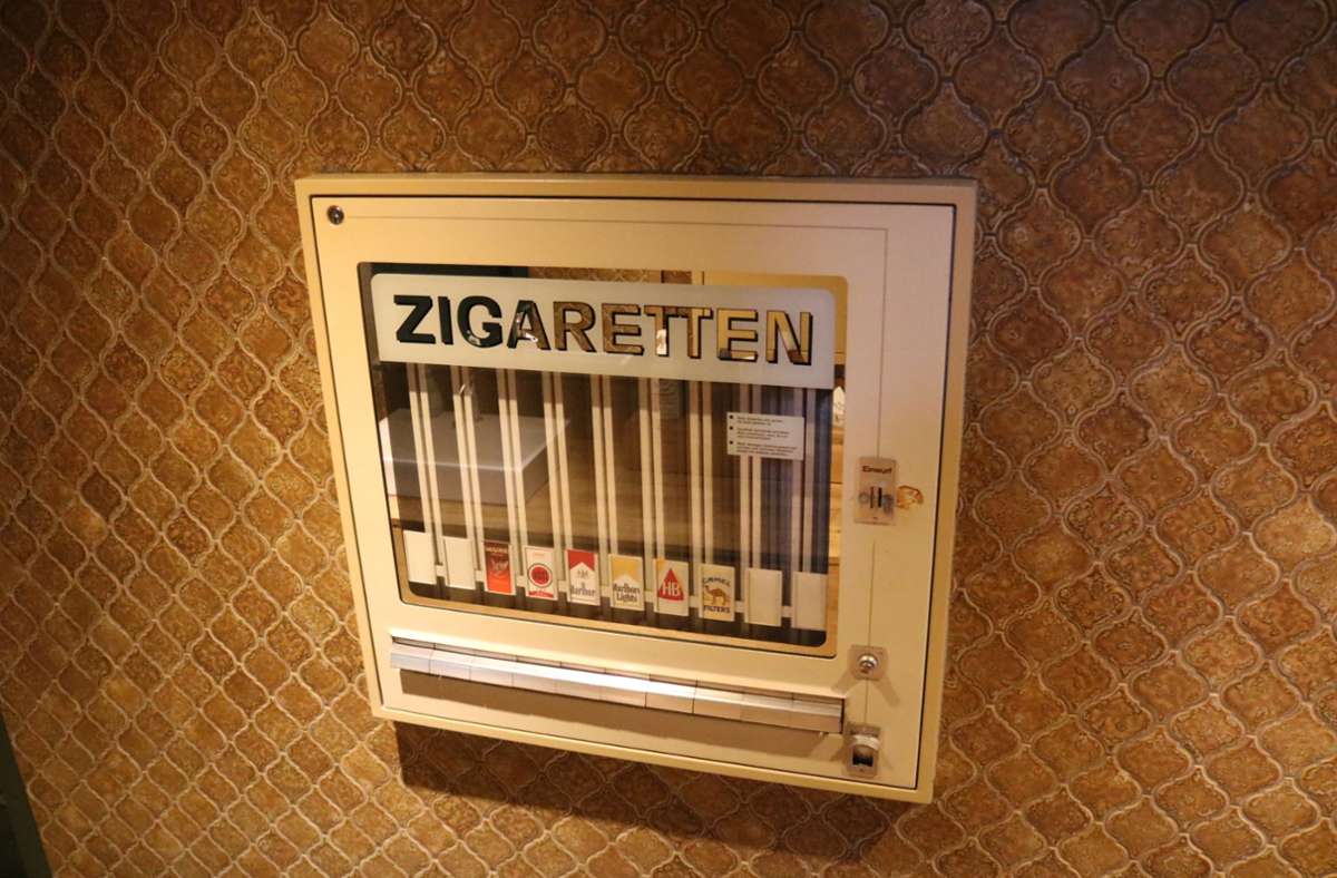Ein leerer Zigarettenautomat dient als Wanddeko.