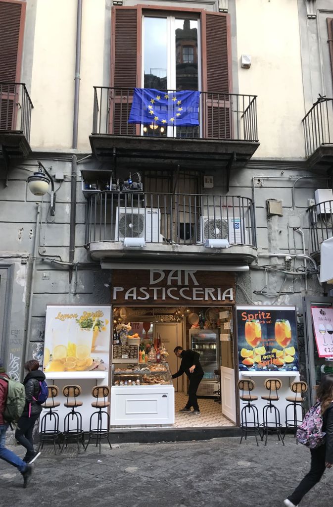 Die Via Tribunali in Neapels Altstadt, hier finden sich die meisten Pizzerien der Stadt. Über dieser Bar hat ein Bewohner die europäische Flagge gehisst.