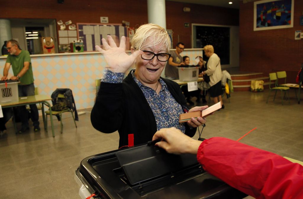 Eine Katalanin gibt freudig ihre Stimme in einem Wahllokal ab.
