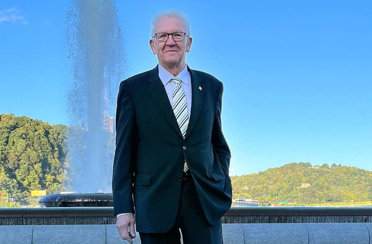 Winfried Kretschmann (Bündnis 90/Die Grünen), Ministerpräsident von Baden-Württemberg, steht auf einem Platz vor einem Brunnen in Pittsburgh. Foto: dpa/Nico Pointner
