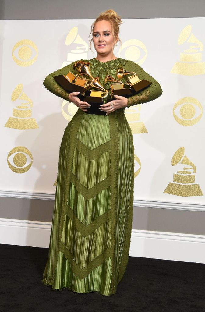 Adele präsentiert stolz ihre fünf Grammys. David Bowie wurde posthum ebenfalls mit fünf Preisen geehrt.
