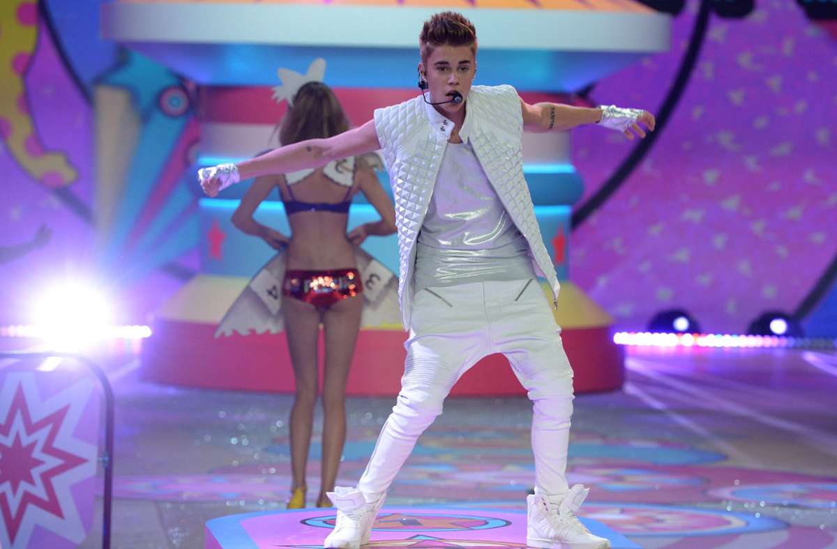 Achtung, die Hose rutscht (nicht wirklich)! Justin Bieber inmitten von Unterwäschemodels bei der New Yorker Victoria’s Secret Fashion Show im Jahr 2012. Bieber liebt weiße Kostümierungen für seine Bühnenauftritte.