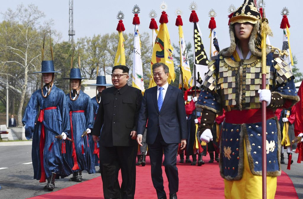 Kim Jong Un und Moon Jae In gehen nebeneinander, kurz nachdem Kim die Grenze nach Südkorea übertreten hat.