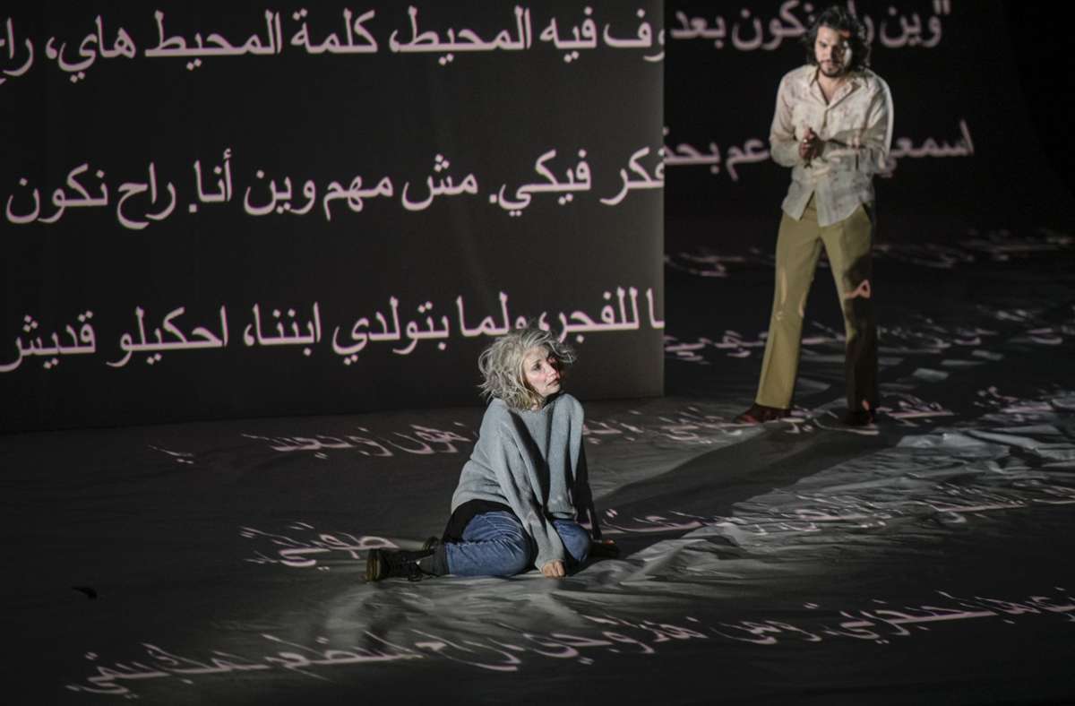 Gespielt und Text auf die Bühne projiziert wird auf Arabisch, Hebräisch, Deutsch und Englisch. Szene mit Evgenia Dodina und Noah Baraa Meskina.
