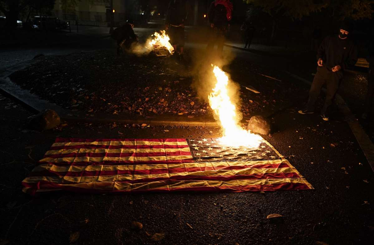 Aktivisten haben US-Flaggen angezündet.