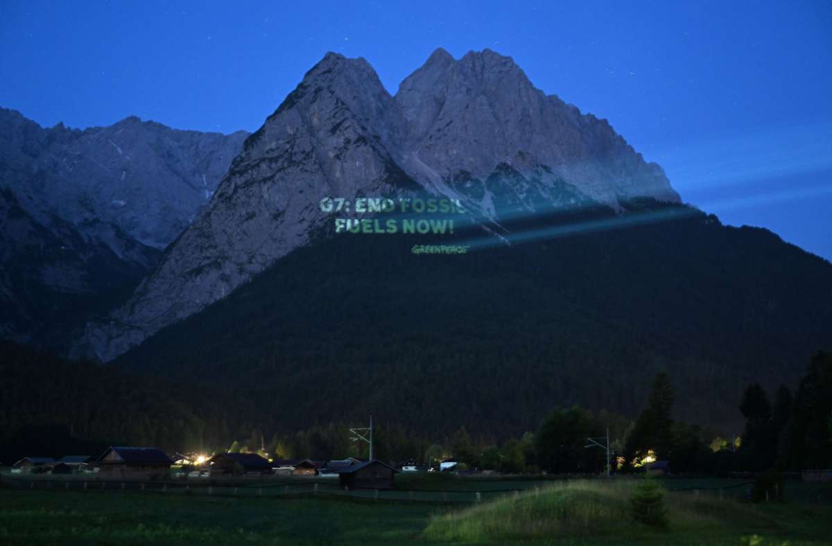 27.Juni 2022, Bayern, Garmisch-Partenkirchen: die Projektion von Greenpeace auf der Bergwand.