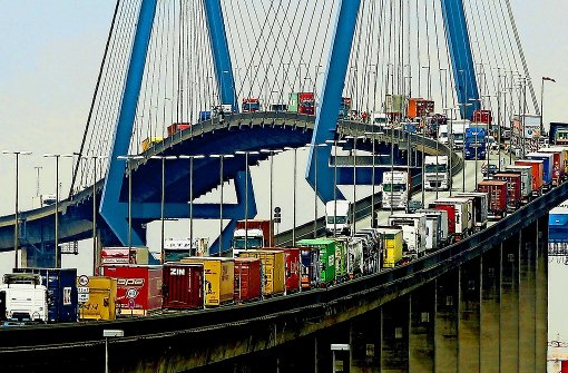 Mit Containern beladene Lastwagen stauen sich auf der Köhlbrandbrücke im Hafen von Hamburg: Mehr als ein Jahrzehnt lang hat fast ­die gesamte Lastwagenbranche ihre Kunden in Europa durch illegale Absprachen geschröpft. Foto: dpa