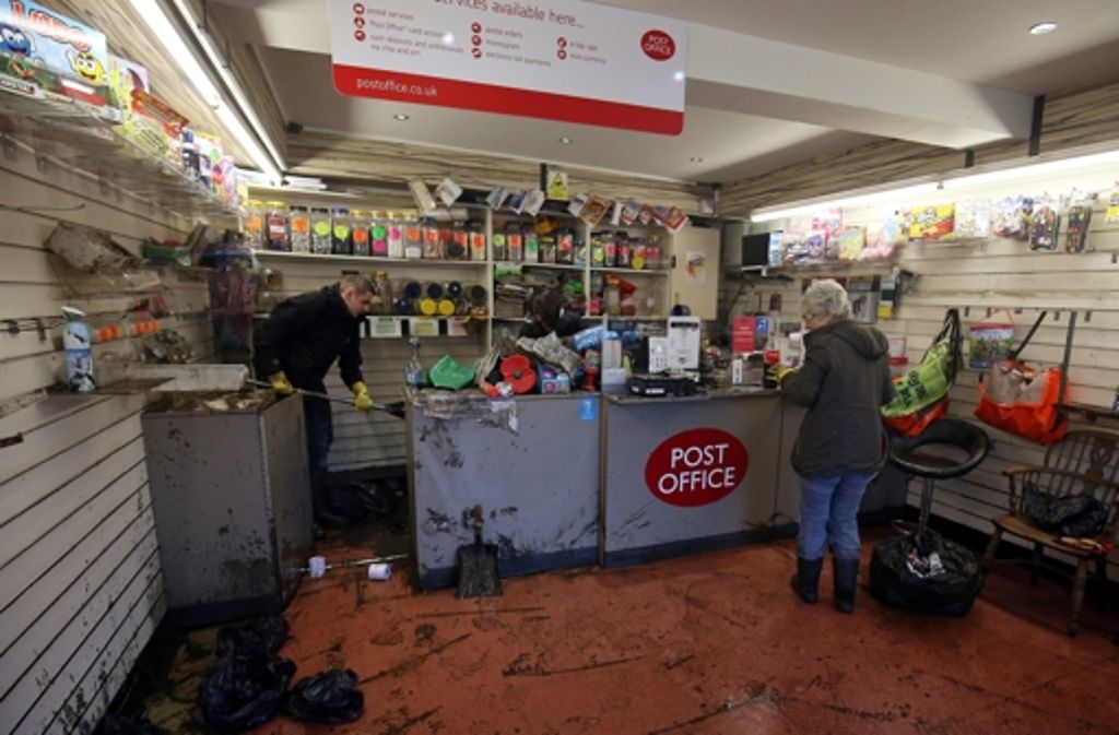 Mythelmroyd, Nordengland: Ladenbesitzer räumen ihre überschwemmten Läden aus.
