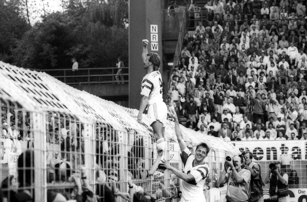 Auf dem Zaun stehend bejubelt Fritz Walter einen Treffer beim 3:0-Sieg. Manfred Schnalke sichert ab.
